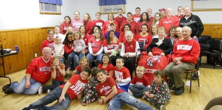 Large family posing for photo with all Wisconsin Badger attire on